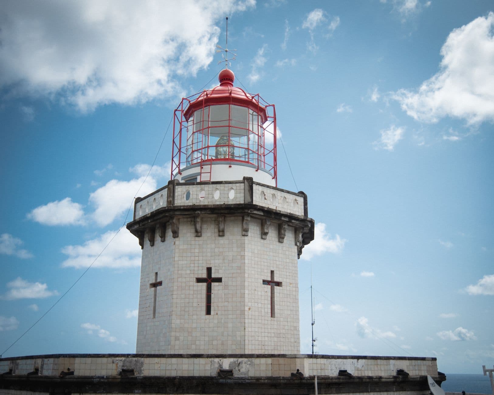 Phare des Capelinhos à demi enseveli sous les cendres, sur fond de paysage volcanique gris à Faial